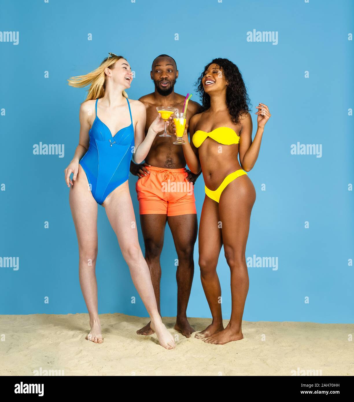 Des moments heureux. Heureux les jeunes amis se reposer et s'amuser sur fond studio bleu. Concept d'émotions humaines, expression du visage, vacances d'été ou de fin de semaine. Chill, été, mer, océan. Banque D'Images