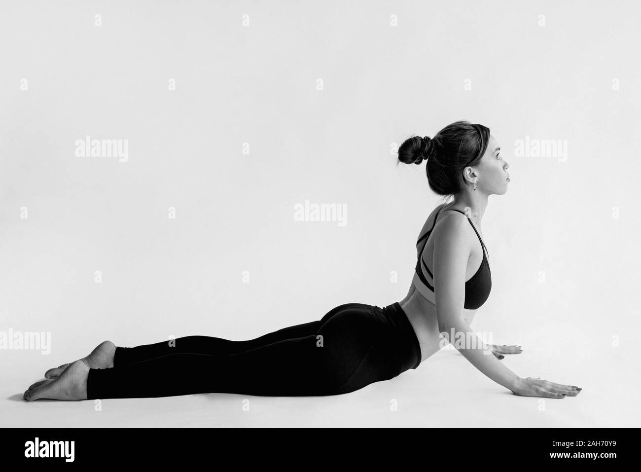 Portrait monochrome de blancs belle brunette cheerful woman doing yoga asanas. Mode de vie sain et sport concept Banque D'Images