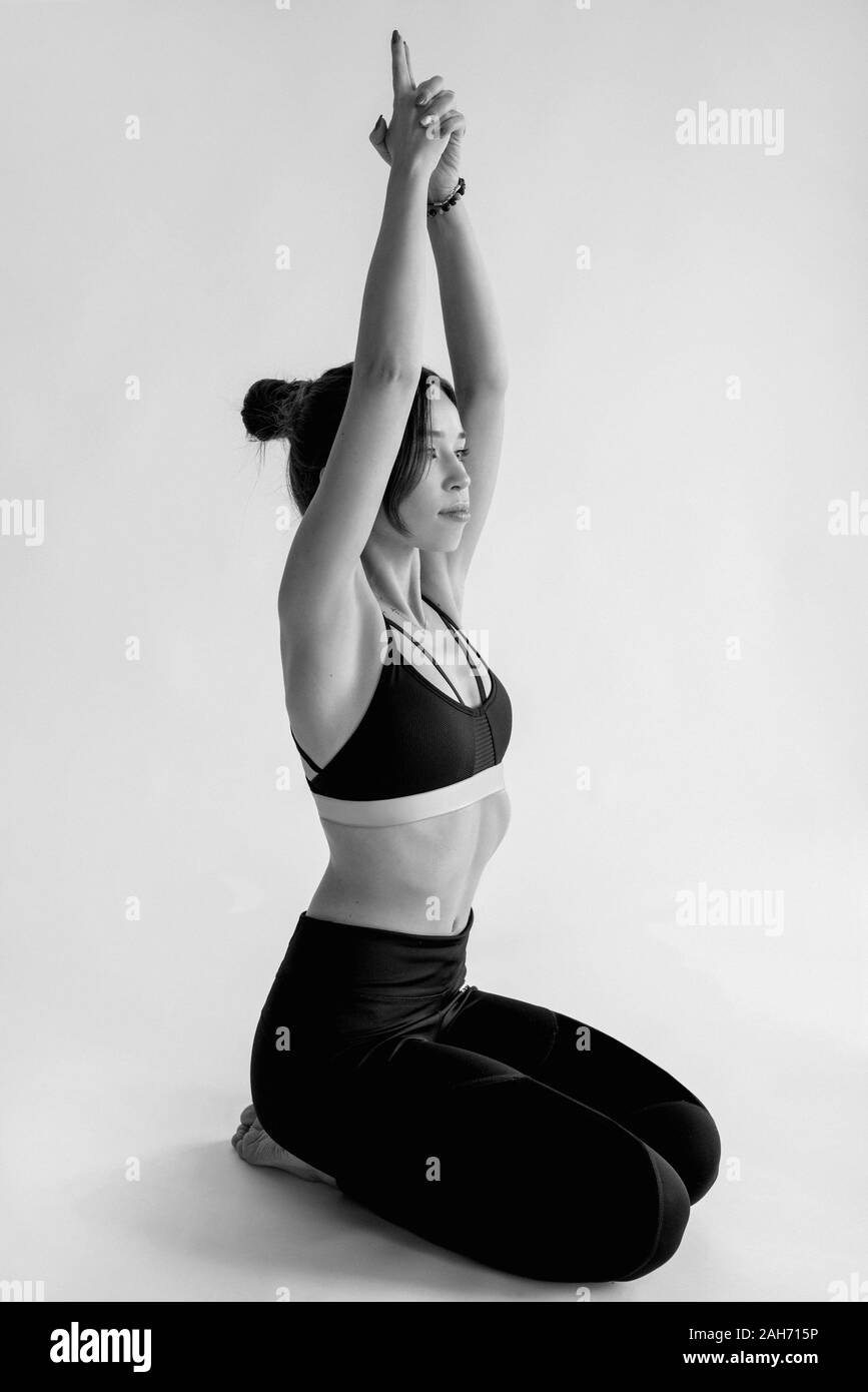 Portrait monochrome de blancs belle brunette cheerful woman doing yoga asanas. Mode de vie sain et sport concept Banque D'Images