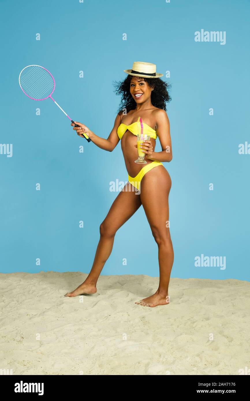 Meilleurs souvenirs. Happy young woman avec racket et des palmes sur fond studio bleu. Concept d'émotions humaines, expression du visage, vacances d'été ou de fin de semaine. Chill, été, mer, océan. Banque D'Images