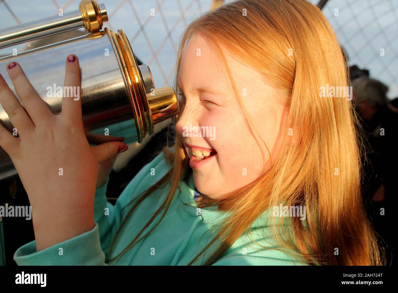 Girl excités au moyen télescope sur Tour Eiffel, Paris Banque D'Images