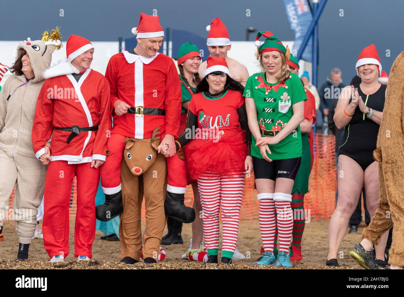 Plage du Jubilé, Marine Parade, Southend on Sea, Essex, Royaume-Uni. Comme c'est devenu une tradition dans la région de seaside endroits, un 'Boxing Day' Dip a eu lieu dans le froid, rugueux Thames Estuary à Southend collecter des fonds pour la RNLI. La plupart des nageurs portaient des habits de fête, courageux Banque D'Images