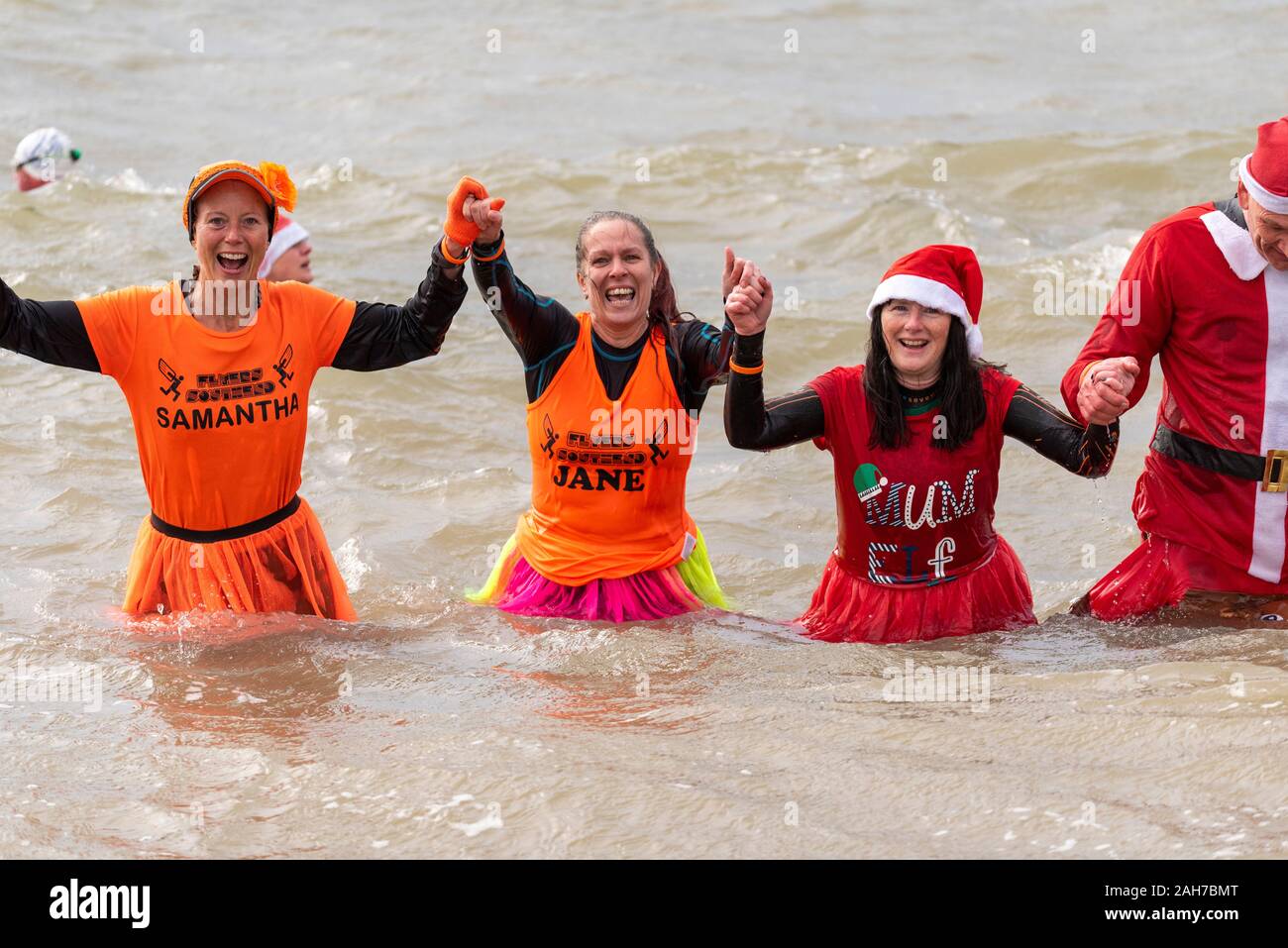 Plage du Jubilé, Marine Parade, Southend on Sea, Essex, Royaume-Uni. Comme c'est devenu une tradition dans la région de seaside endroits, un 'Boxing Day' Dip a eu lieu dans le froid, rugueux Thames Estuary à Southend collecter des fonds pour la RNLI. La plupart des nageurs portaient des habits de fête, courageux Banque D'Images