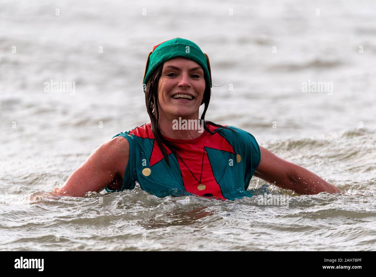 Plage du Jubilé, Marine Parade, Southend on Sea, Essex, Royaume-Uni. Comme c'est devenu une tradition dans la région de seaside endroits, un 'Boxing Day' Dip a eu lieu dans le froid, rugueux Thames Estuary à Southend collecter des fonds pour la RNLI. La plupart des nageurs portaient des habits de fête, courageux Banque D'Images