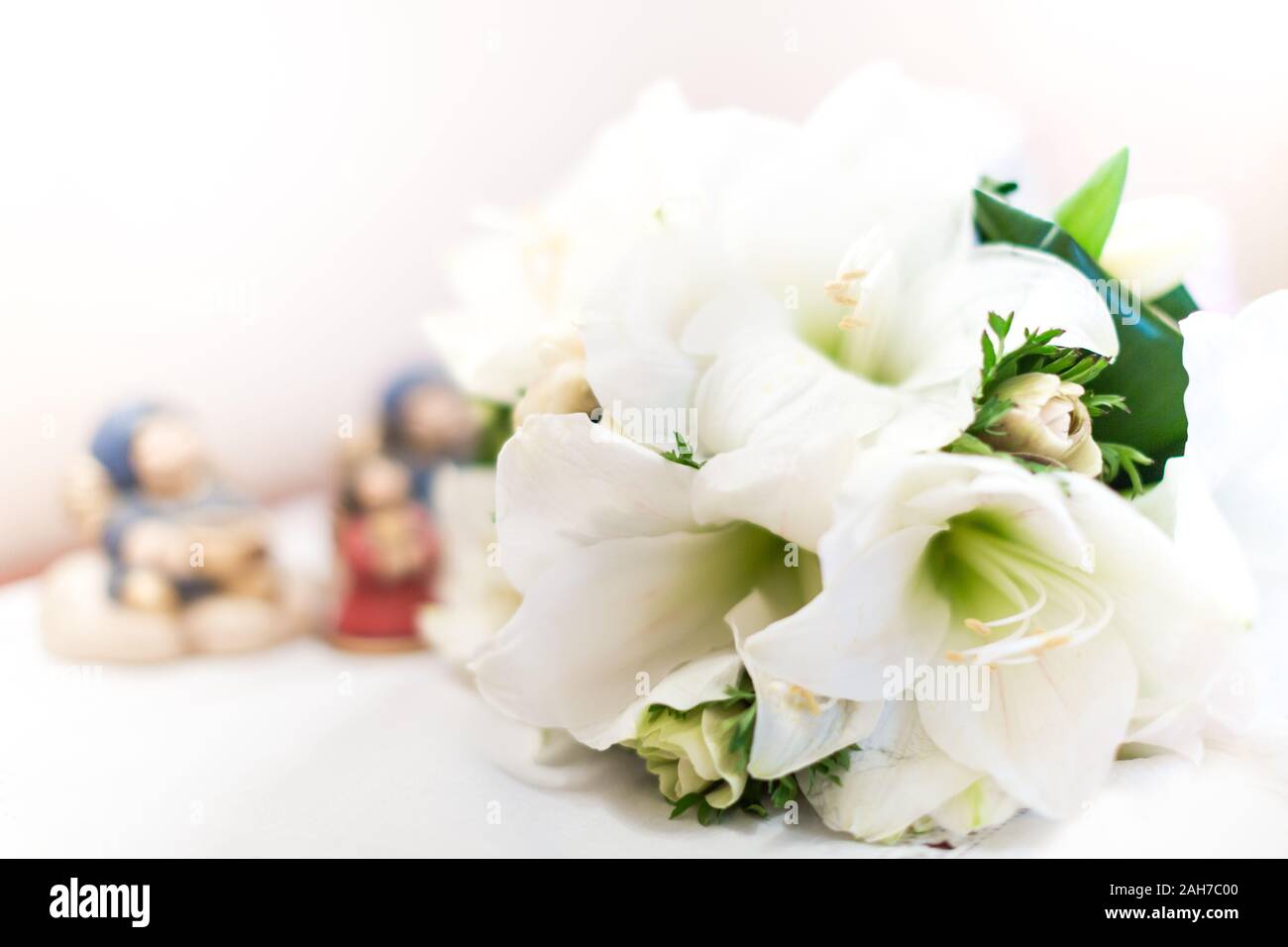 Gros plan d'un bouquet de mariage blanc composé de nénuphars blancs posés sur une table sur un fond bokeh Banque D'Images