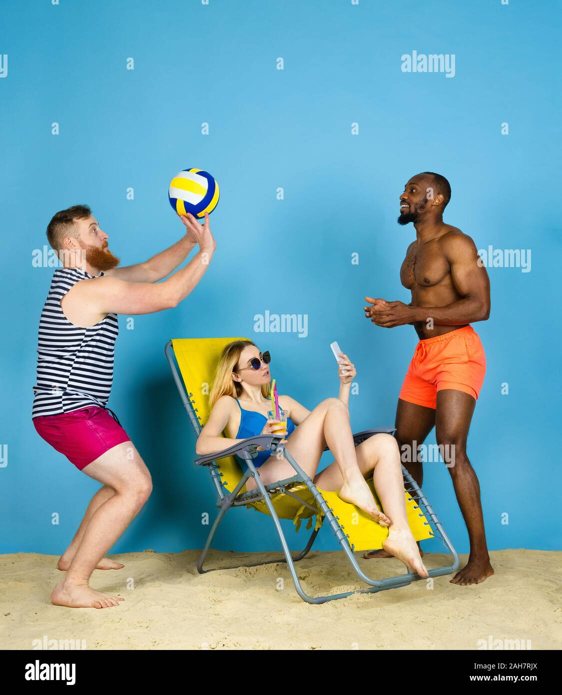 Temps pour l'activité. Happy friends prendre, jouer au volley-ball selfies bleu sur fond de studio. Concept d'émotions humaines, expression du visage, vacances d'été ou de fin de semaine. Chill, été, mer, océan. Banque D'Images