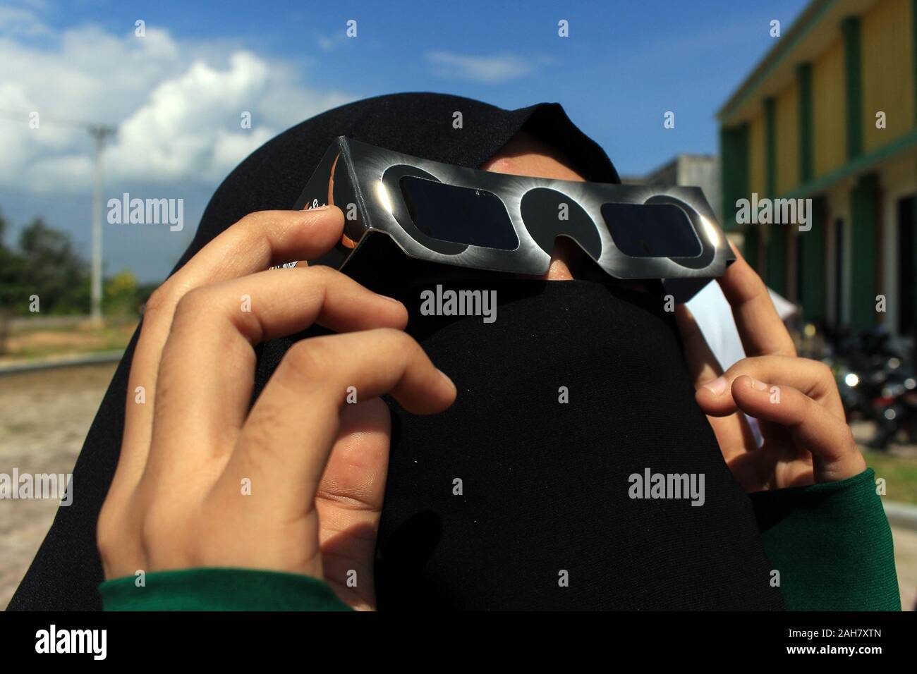 Une femme porte des lunettes de protection des yeux pour regarder le cercle  de feu Eclipse solaire à Lhokseumawe.Le cercle de feu Eclipse solaire s'est  produite lors de l'ombre de la Lune