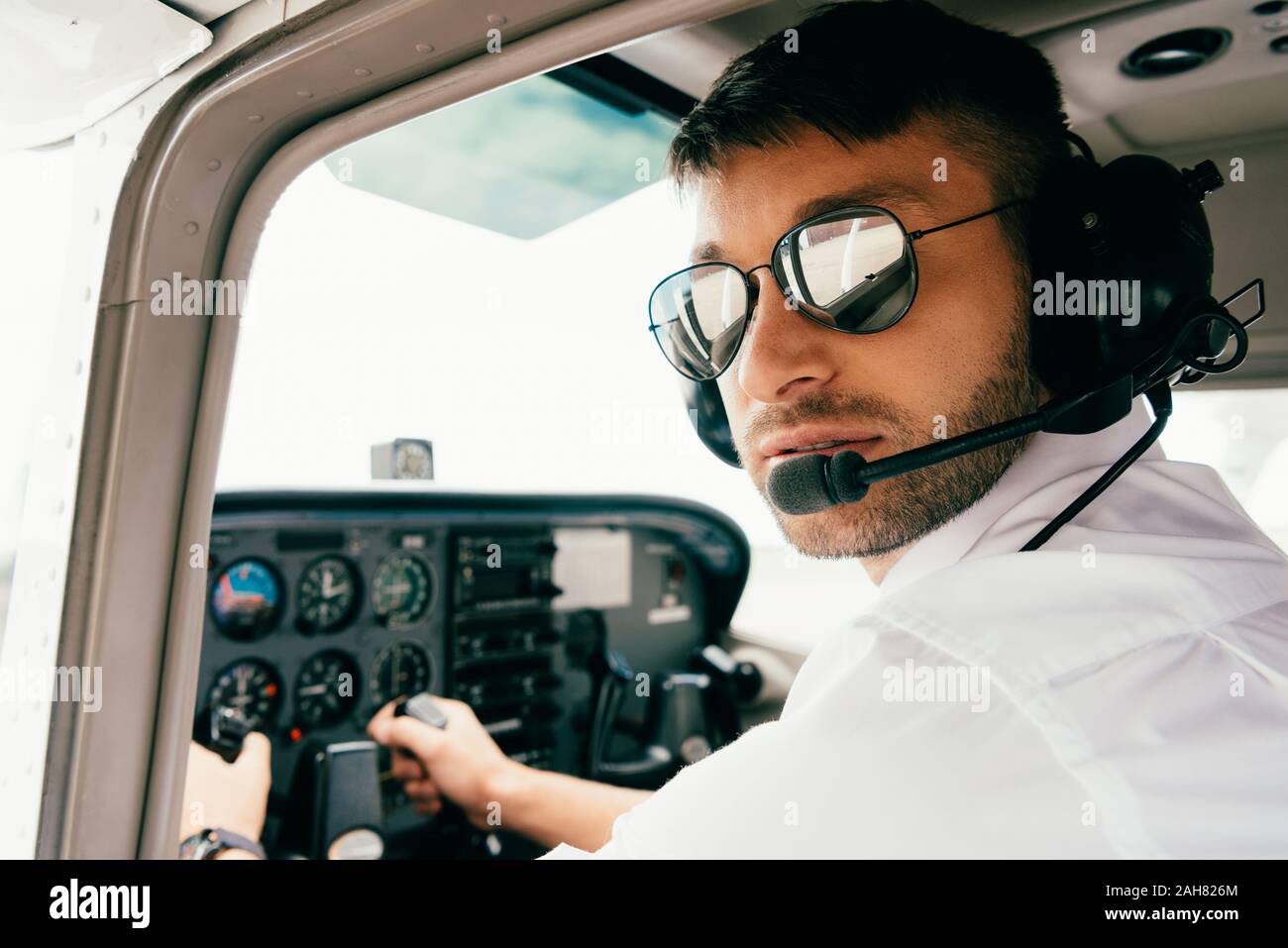 Pilote en lunettes de soleil et de casque en avion Photo Stock - Alamy