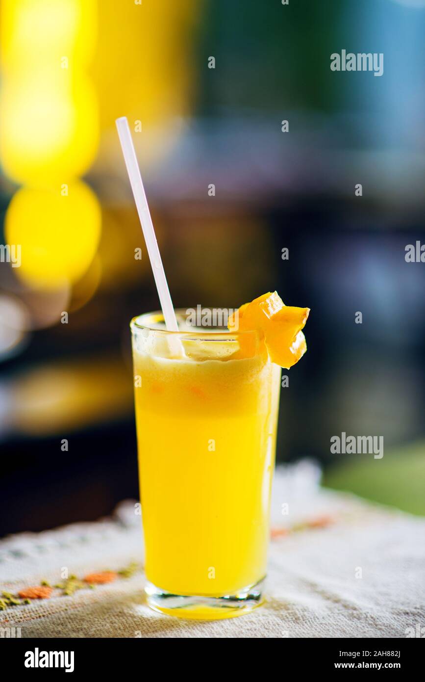 Jus de mangue frais tropicaux avec de la paille dans un verre décoré d'une tranche de carambole. Banque D'Images
