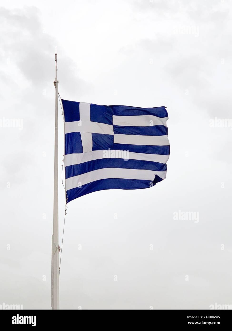 Brandissant le drapeau national de la Grèce. Appelé aussi le bleu ciel et blanc. Morceau de tissu et une bannière, utilisée comme symbole du pays patriotique. Banque D'Images