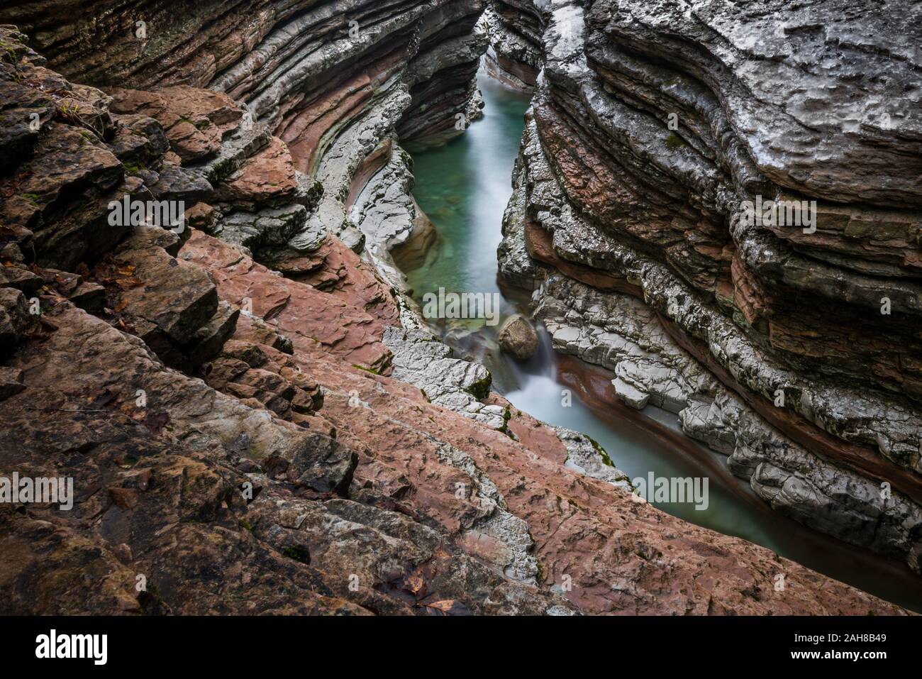 Vue grand angle d'un canyon en grès rouge avec un ruisseau qui coule dans son fond Banque D'Images