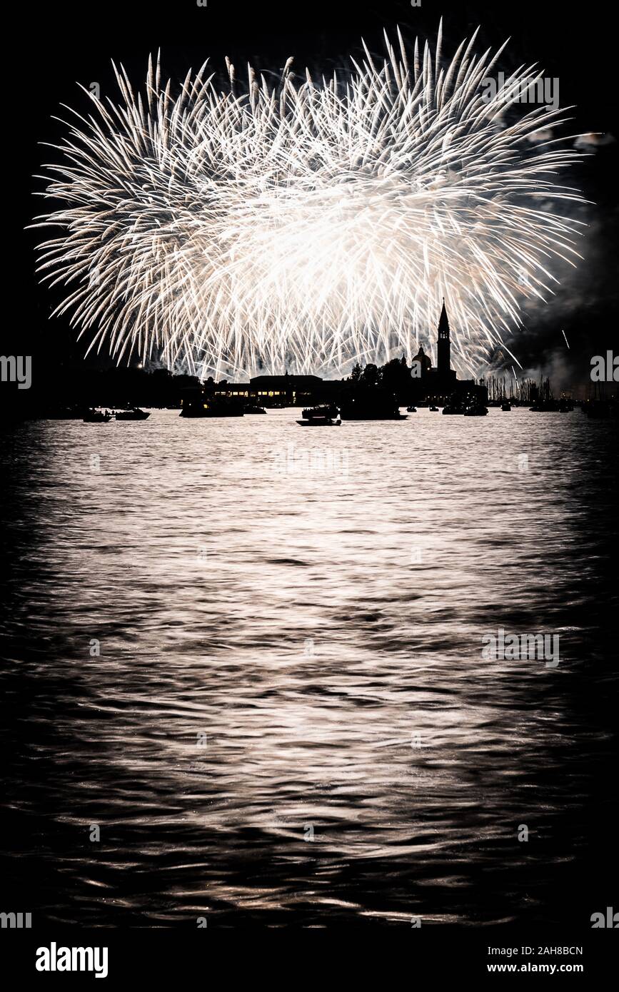 Photo nocturne emblématique de Venise, dont la silhouette est éclairée par des feux d'artifice blancs Banque D'Images