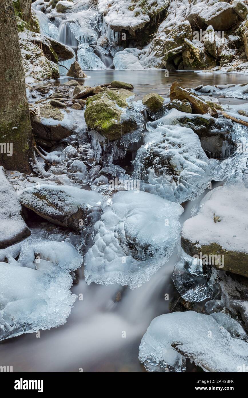 Vue rapprochée d'un certain nombre de rapides de montagne qui circulent entre les rochers enneigés Banque D'Images