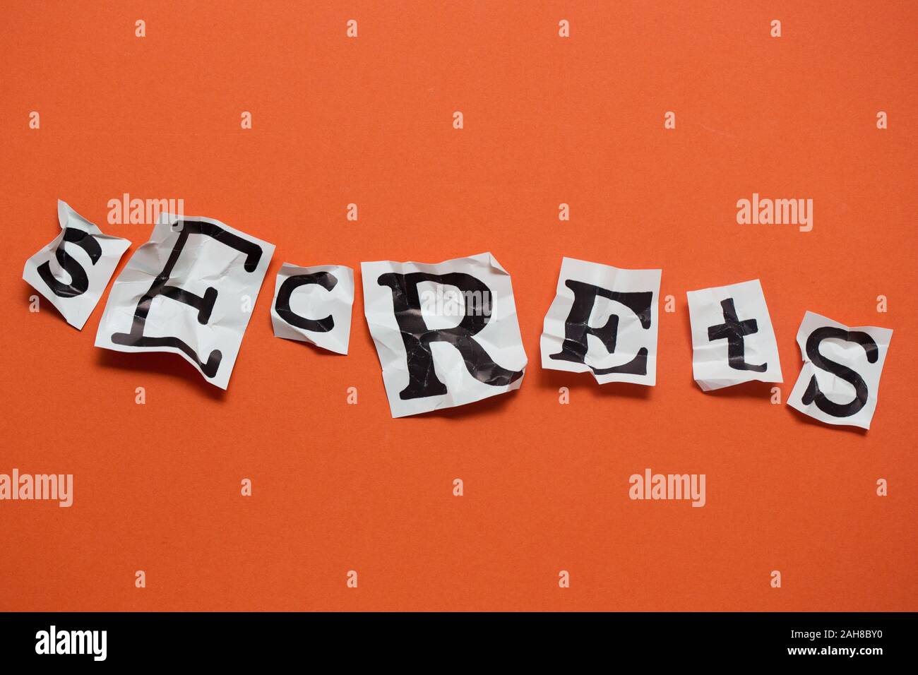 Le mot 'secrets' énoncés dans les lettres de papier froissé. Banque D'Images