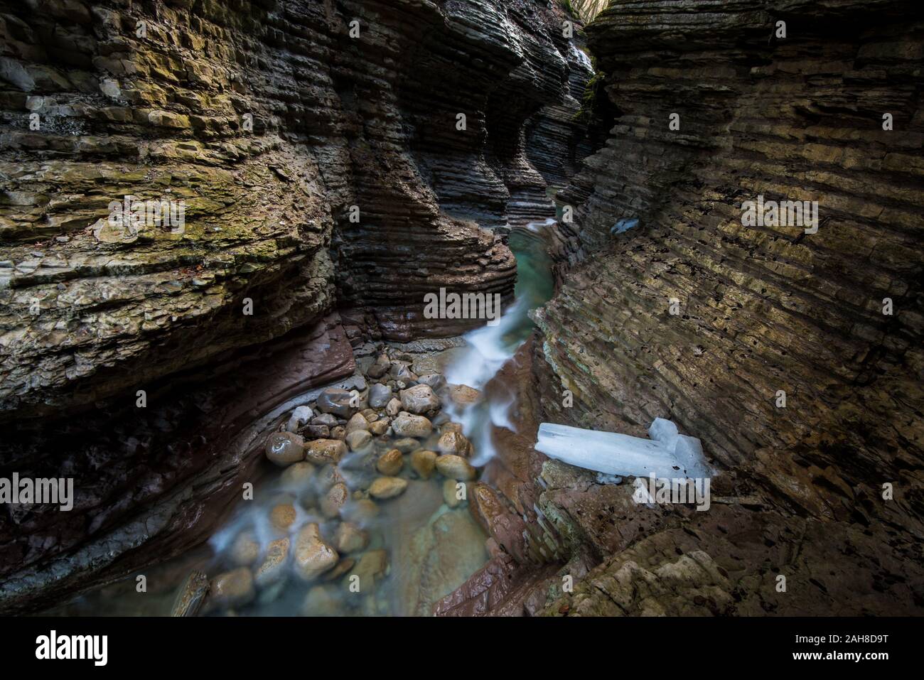 Vue grand angle de l'intérieur d'un canyon de grès rouge avec un ruisseau en bas Banque D'Images