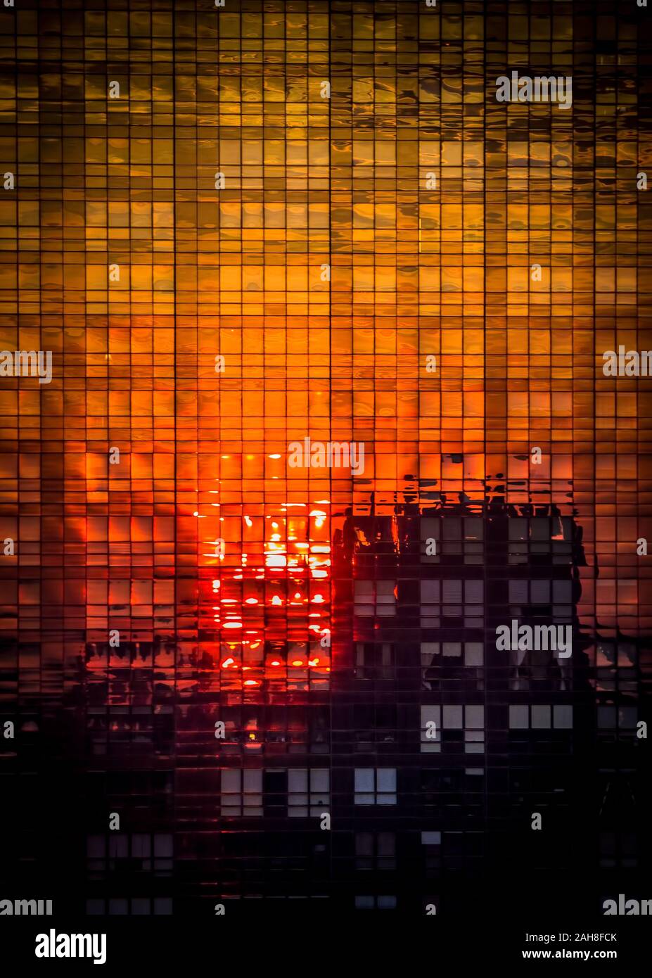 Coucher de soleil coloré reflété sur la façade de verre d'un gratte-ciel à Manhattan Banque D'Images