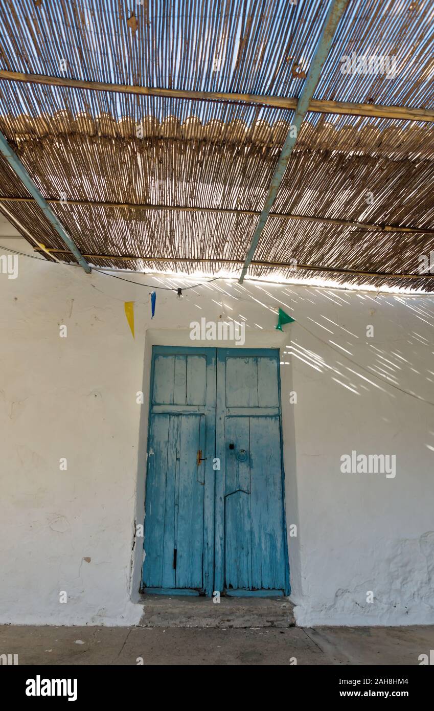 Porte en bois bleu et toit de paille, avec des rayons de lumière et ombre à abadoned église Ermita de Sant Antoni et Sant Jaume vertical au capuchon, Al Banque D'Images