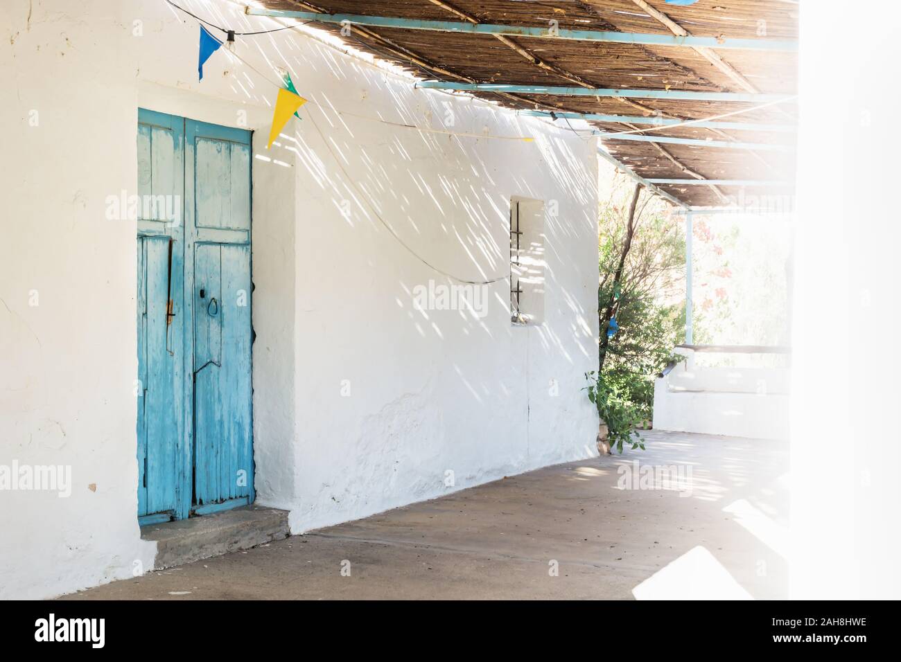 Bleu allégé porte en bois et toit de paille, avec des rayons de lumière et ombre à abadoned église Ermita de Sant Antoni et Sant Jaume à capuchon, un Banque D'Images