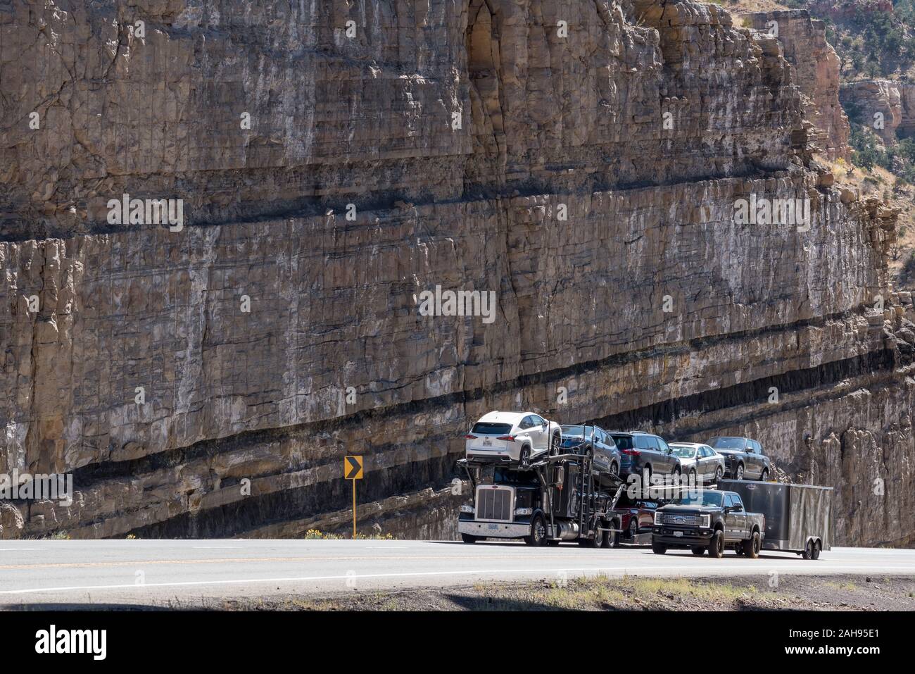 Camions roulant dans une tranchée de route avec les couches de charbon sur la route 6 dans la région de Carbon County, Utah. Banque D'Images