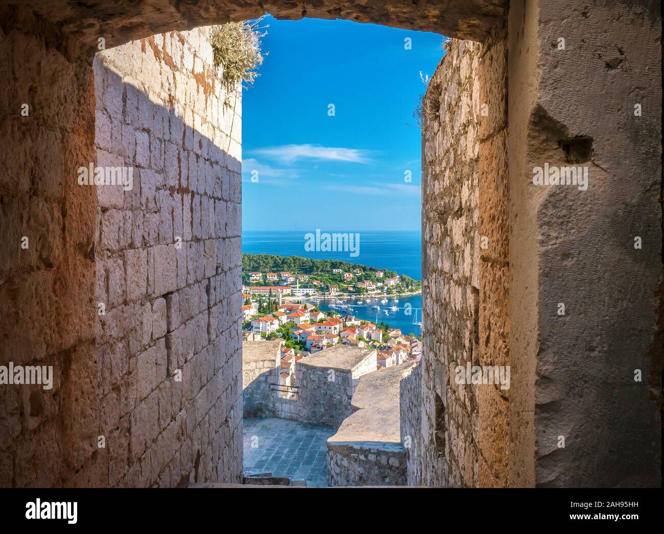 Une vue magnifique du port de Hvar vu par un étroit passage d'entrée dans la forteresse de pierre médiévale situé au-dessus de la ville. Banque D'Images