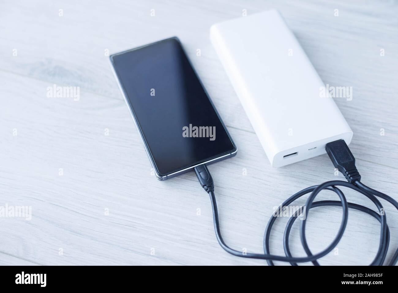 Le téléphone se recharge avec la banque d'alimentation. Banque d'alimentation portable Banque D'Images