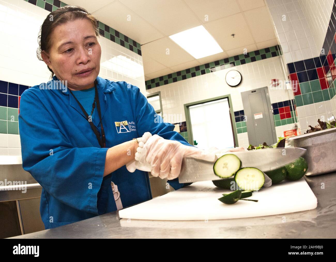 Food Service Manager Hoa Tran concombres tranches pour les salades en préparation à l'école élémentaire de Nottingham à Arlington, VA, le mercredi, Octobre 12, 2011. Banque D'Images