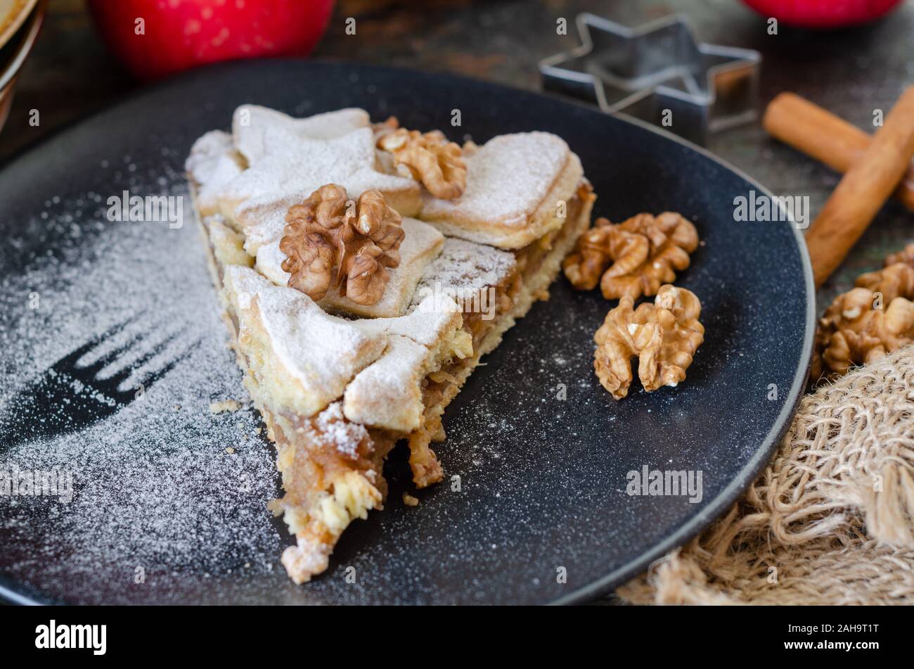 Tranche de tarte aux pommes faite maison fraîchement préparés et les noix sur la plaque noire Banque D'Images