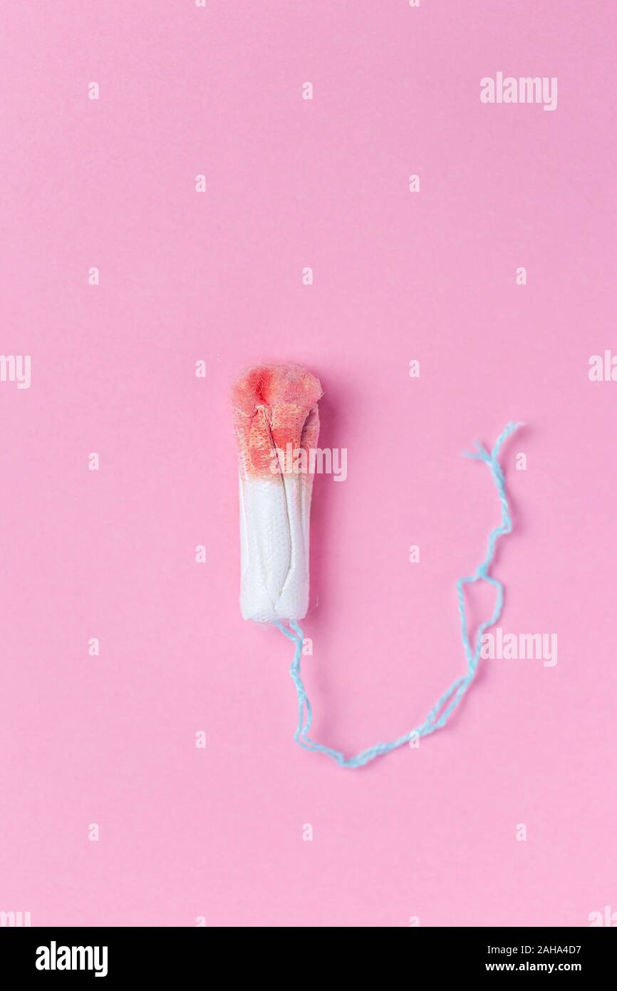 Utilisé sur un tampon féminin médical fond rose. La menstruation, moyens de protection. Simulation du cycle menstruel sur coton-tige Banque D'Images