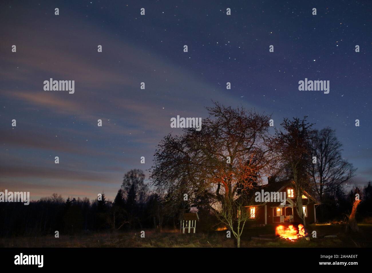 12.04.2017, Hovmantorp, Kronobergs laen, Suède - les gens assis à un feu de camp en face d'une maison de vacances. 00S170412D054CAROEX.JPG [communiqué de modèle : Non Banque D'Images 12.04.2017, Hovmantorp, Kronobergs laen, Suède - les gens assis à un feu de camp en face d'une maison de vacances. 00S170412D054CAROEX.JPG [communiqué de modèle : Non Banque D'Images