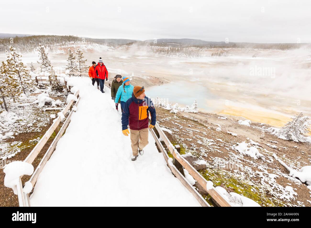Les touristes à pied le long d'une promenade couverte de neige autour du bassin en porcelaine au Norris Geyser Basin en hiver 20 décembre 2019 au Parc National de Yellowstone, Wyoming. Banque D'Images