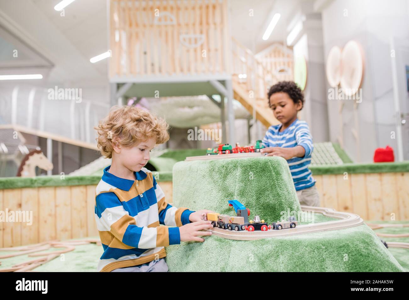 Deux adorables petits garçons de casualwear jouant ensemble sur les trains jouets jeux Banque D'Images