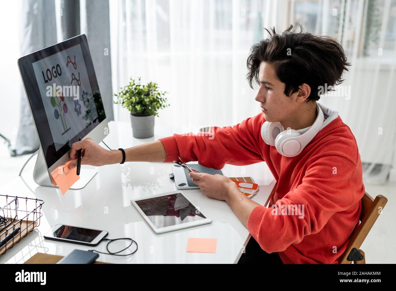 Concepteur de jeunes hommes avec des couleurs du nuancier mettre les notes sur ordinateur Banque D'Images