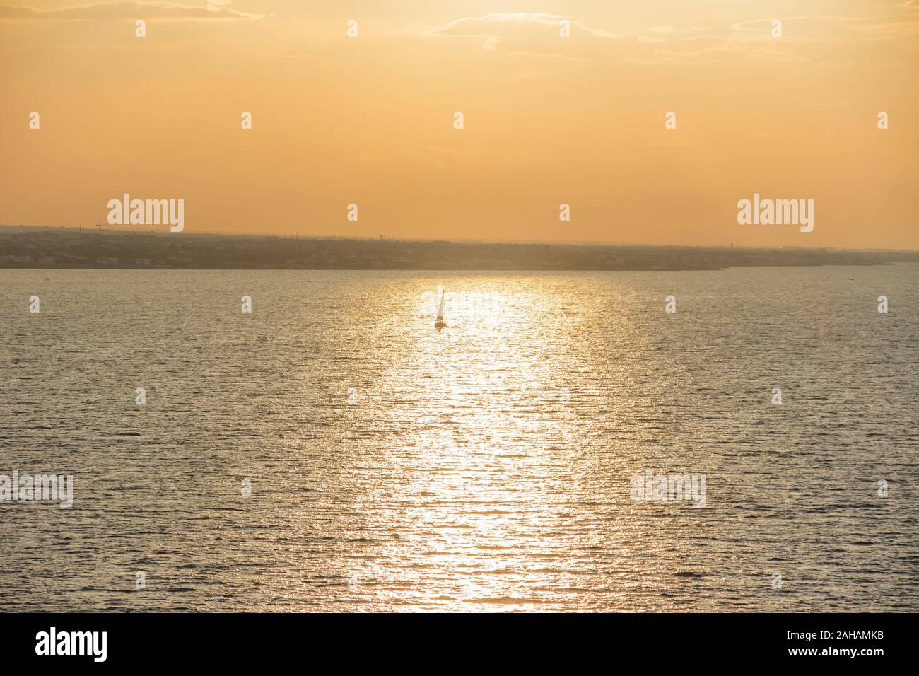 Coucher De Soleil Voile. Image Seascape avec mer brillante et voilier sur ciel nuageux et soleil pendant le coucher du soleil côte d'Pouilles, Italie. Banque D'Images