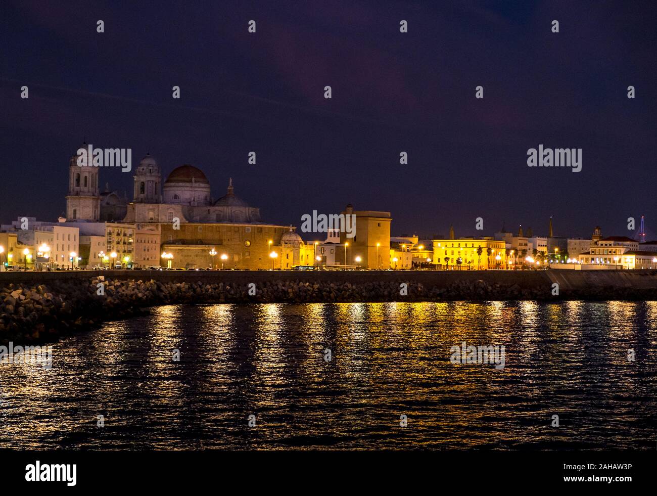 Zone Harbourfront à Cadix, en Espagne, de nuit, avec Catedral de Cádiz allume à l'arrière-plan Banque D'Images