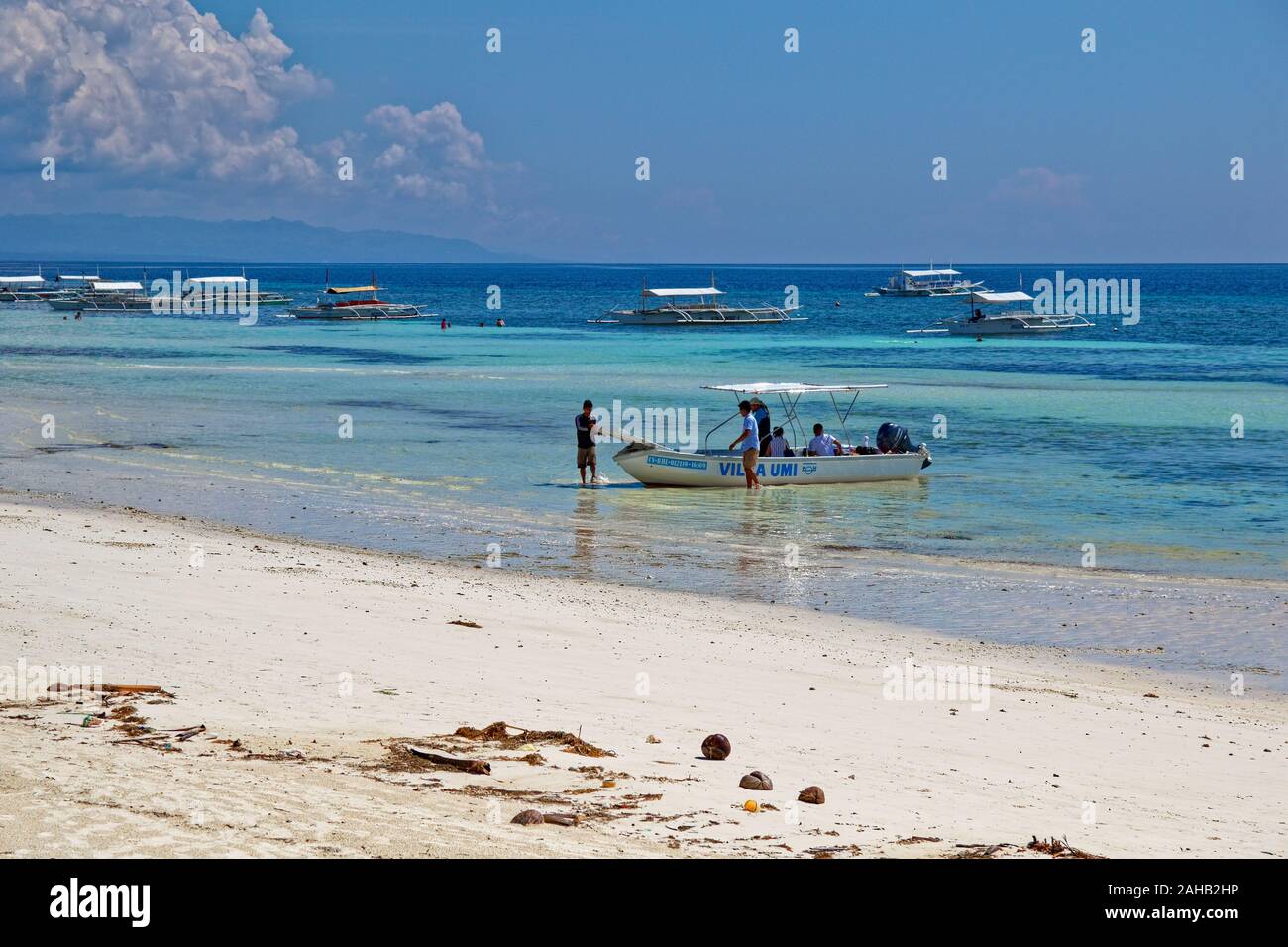 Bateau d'amarrage de l'homme avec des personnes à bord en Philipine beach Banque D'Images