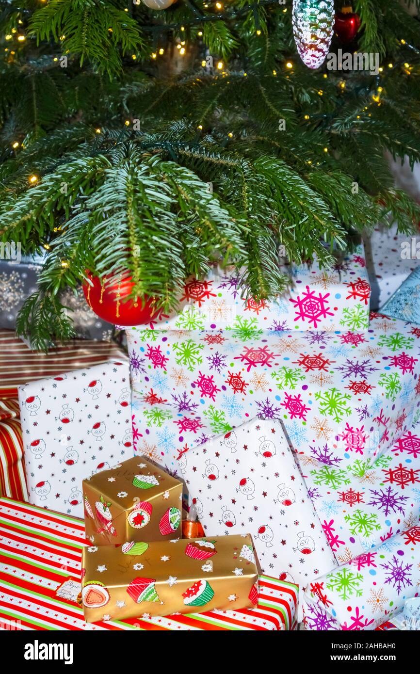 Pile de traditionnelle colorée typique de Noël ou des cadeaux emballés présente sous un arbre de Noël au Royaume-Uni des fêtes Banque D'Images