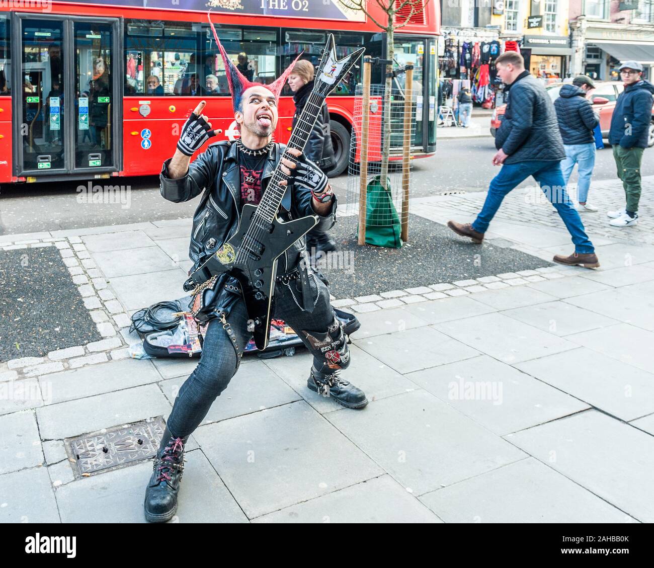 Homme vetu de vetements Punk Rocker avec des cheveux a pointes et une pose de guitare pour des images touristiques sur Camden High Street Camden Londres Royaume Uni Photo Stock Alamy