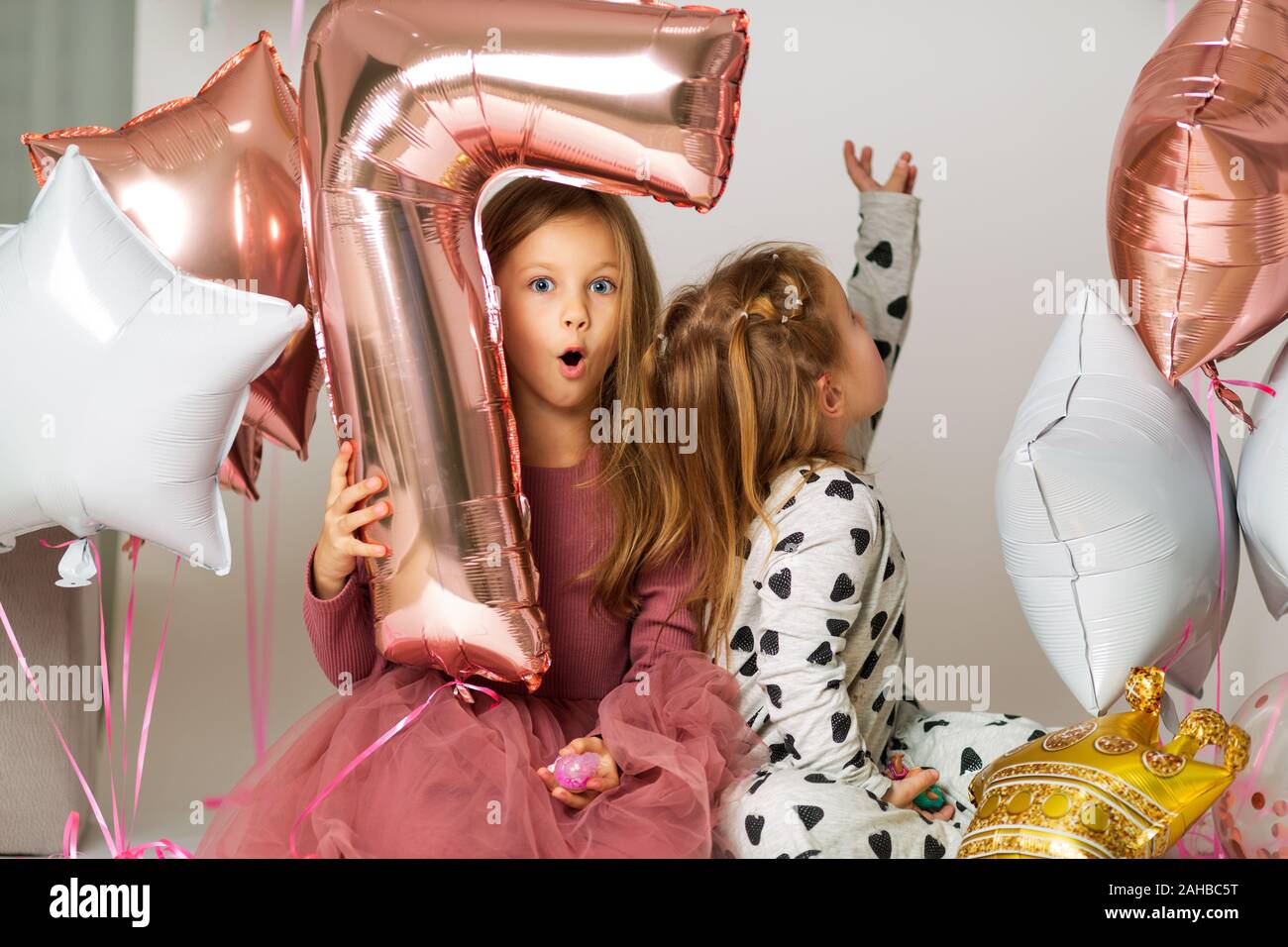 Portrait de deux sœurs, 7 ans, blonde et 3 ans, les soeurs jouer avec des ballons, la bille numéro 7 Banque D'Images