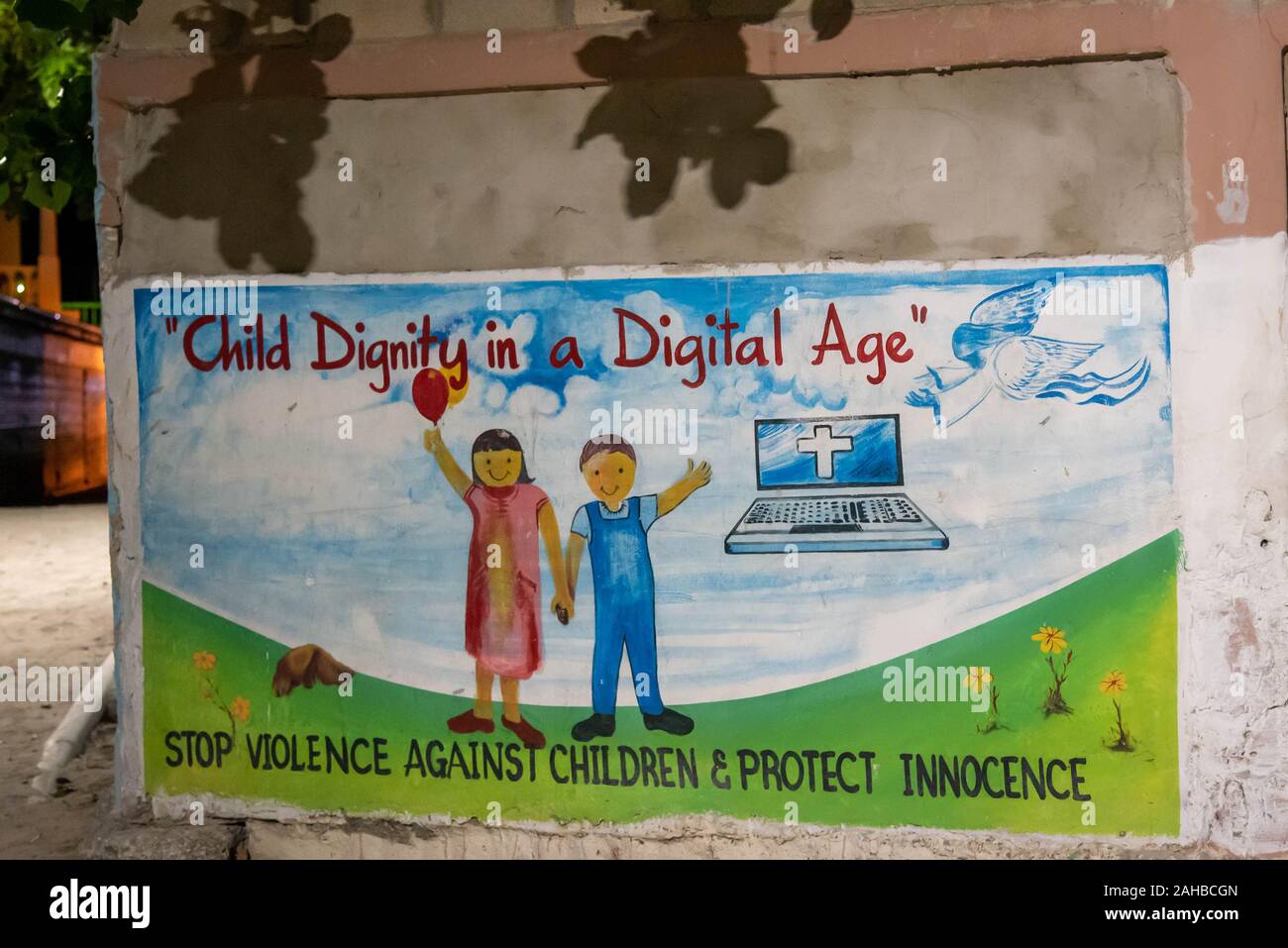 San Pedro, Ambergris Caye, Belize - 17 novembre, 2019. "La dignité de l'enfant dans une ère numérique" murale graffiti religieux peint sur le mur de l'église catholique Banque D'Images