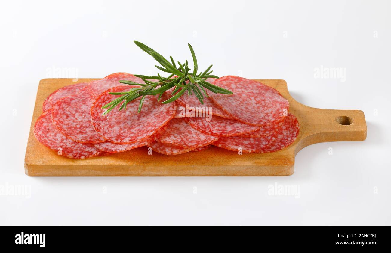 Minces tranches de salami sausage sur planche à découper en bois Banque D'Images Minces tranches de salami sausage sur planche à découper en bois Banque D'Images