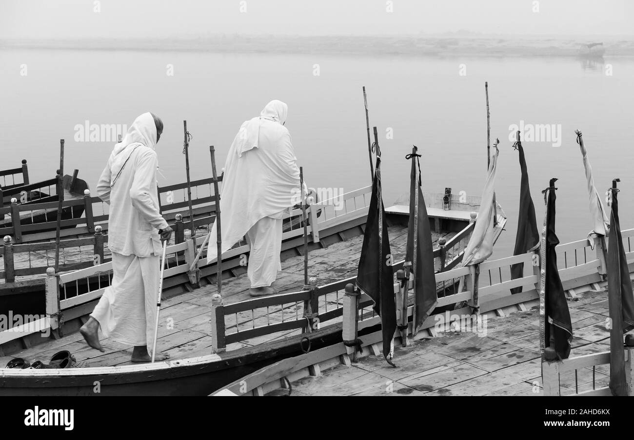 Deux pèlerins hindous debout sur petit bateau dans la médiation sur la rivière Yamuna sainte à l'aube à Vrindavan, Uttar Pradesh, Inde. Banque D'Images