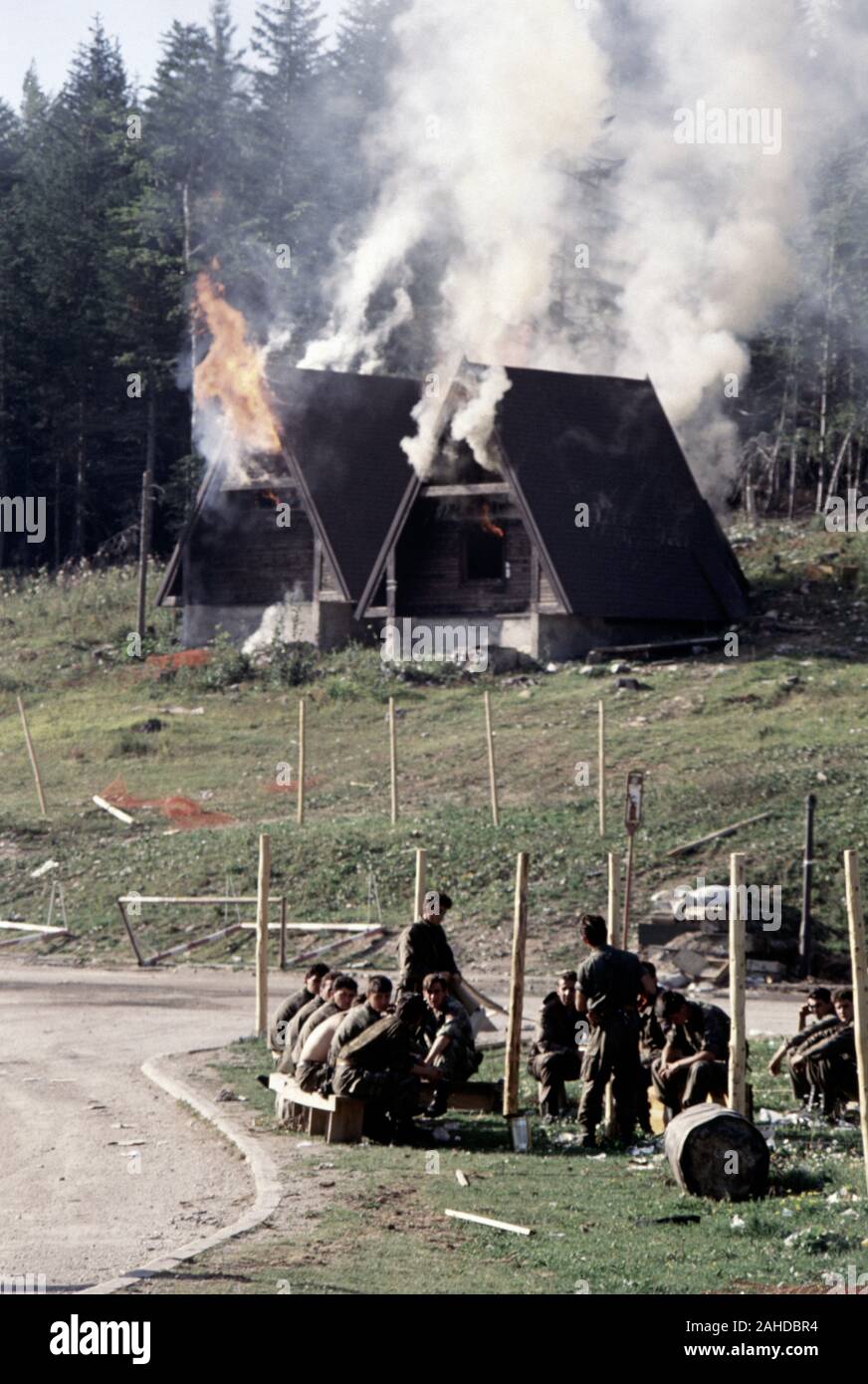 13 août 1993 pendant la guerre en Bosnie : chalets en bois de l'hôtel Famos (aujourd'hui appelé l'hôtel Maršal) brûler derrière la victoire des Serbes de Bosnie (soldats) sur la montagne Bjelašnica. Banque D'Images