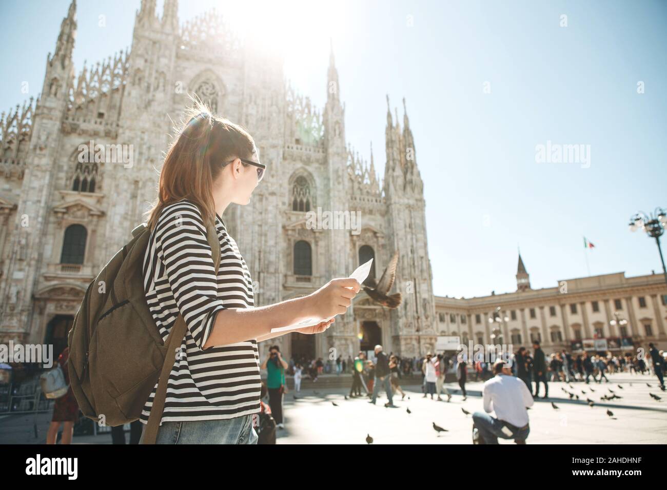 Girl touriste ou étudiant avec un sac à dos ressemble à la carte. Dans l'arrière-plan la cathédrale Duomo de Milan en Italie et méconnaissable. Banque D'Images