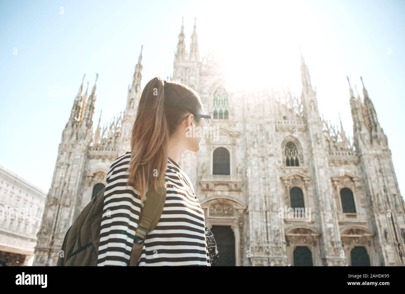Un touriste ou d'étudiant avec un sac à dos se penche sur les sites touristiques de Milan en Italie. Elle admire la cathédrale sur la place de la ville. Banque D'Images