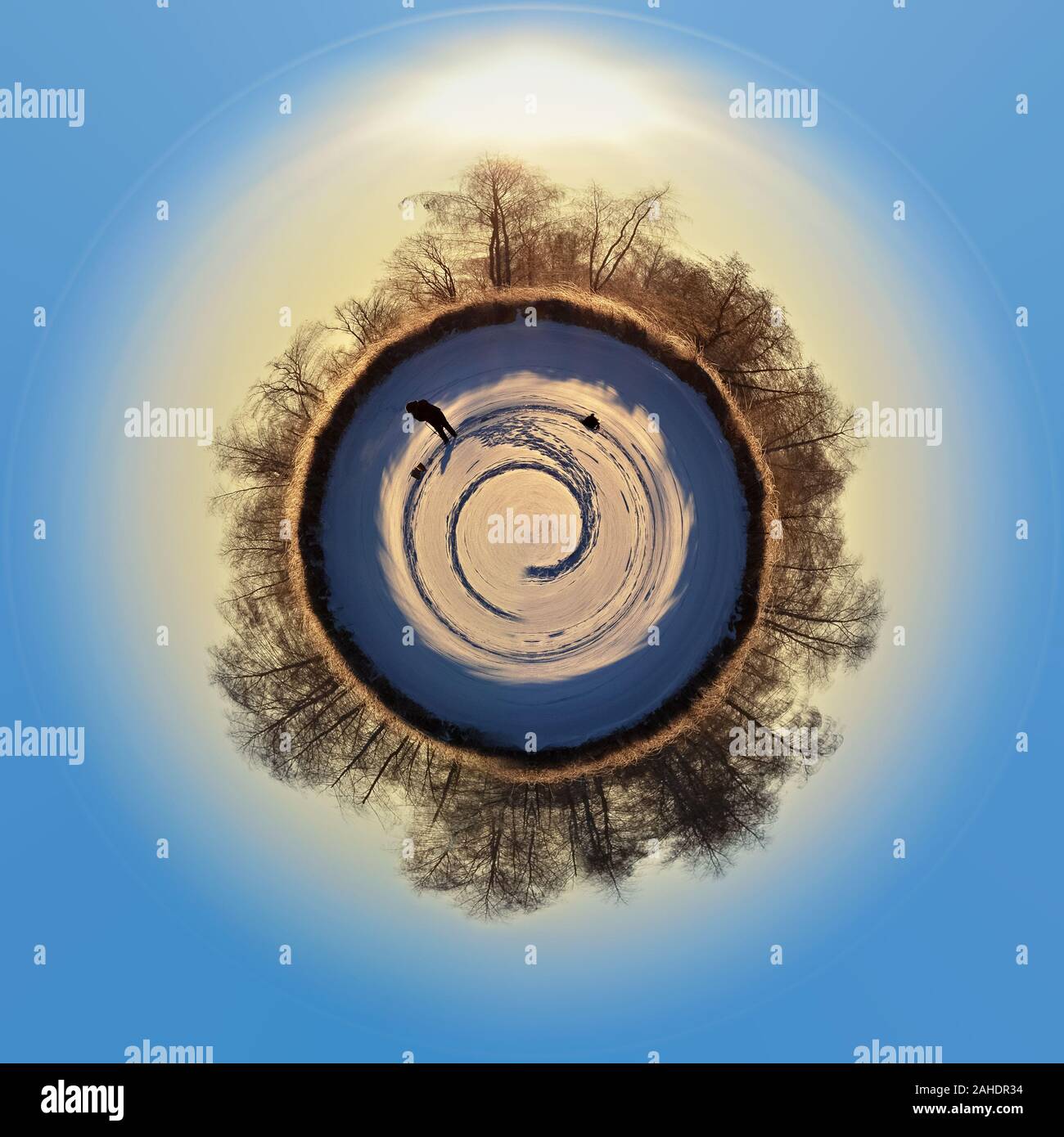 Silhouette d'un pêcheur sur une planète couverte de neige, à la lumière du soleil levant Banque D'Images