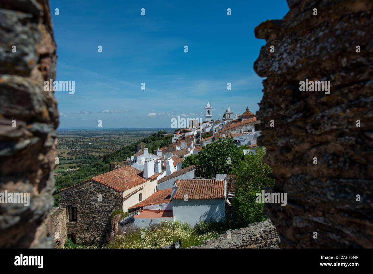 Blick von oben durch eine auf die Maueröffnung Ortschaft Monsaraz und die Landschaft mit einem leicht bewölkten Himmel Banque D'Images