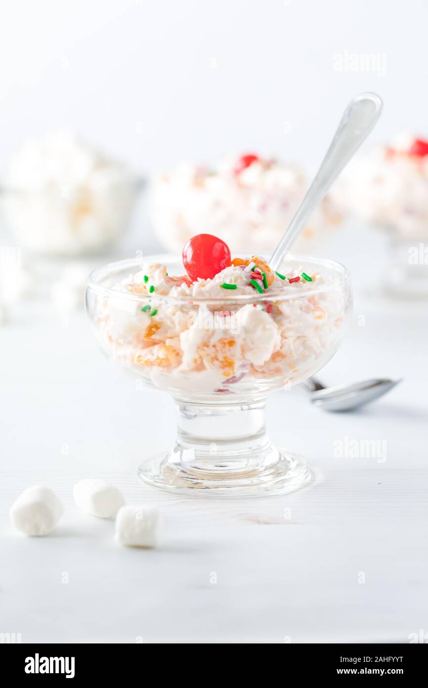 Un gros plan d'une assiette à dessert rempli d'Ambrosia et salade garnie de cerises au marasquin. Banque D'Images