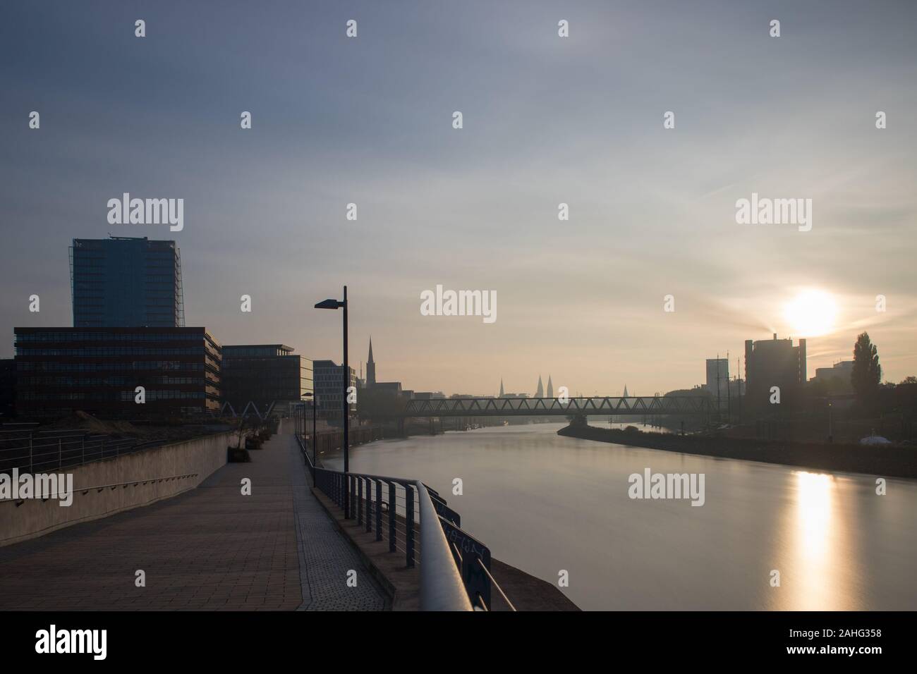 Une longue exposition de la Überseestadt à Brême, en Allemagne avec les immeubles de bureaux et ciel nuageux au lever du soleil Banque D'Images