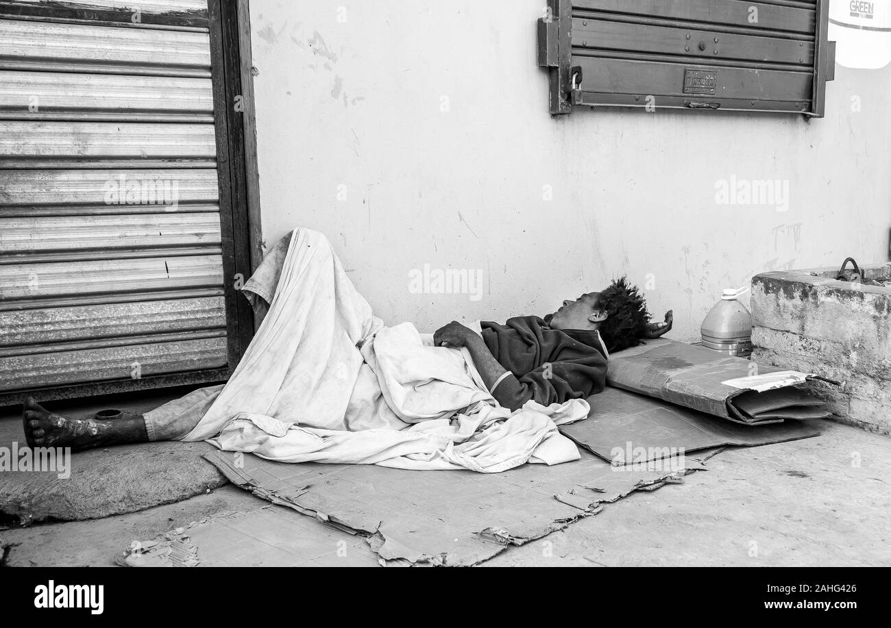 L'image spectaculaire d'une femme sans-abri dormant sur le trottoir dans une petite ville des Caraïbes de la République dominicaine. Banque D'Images