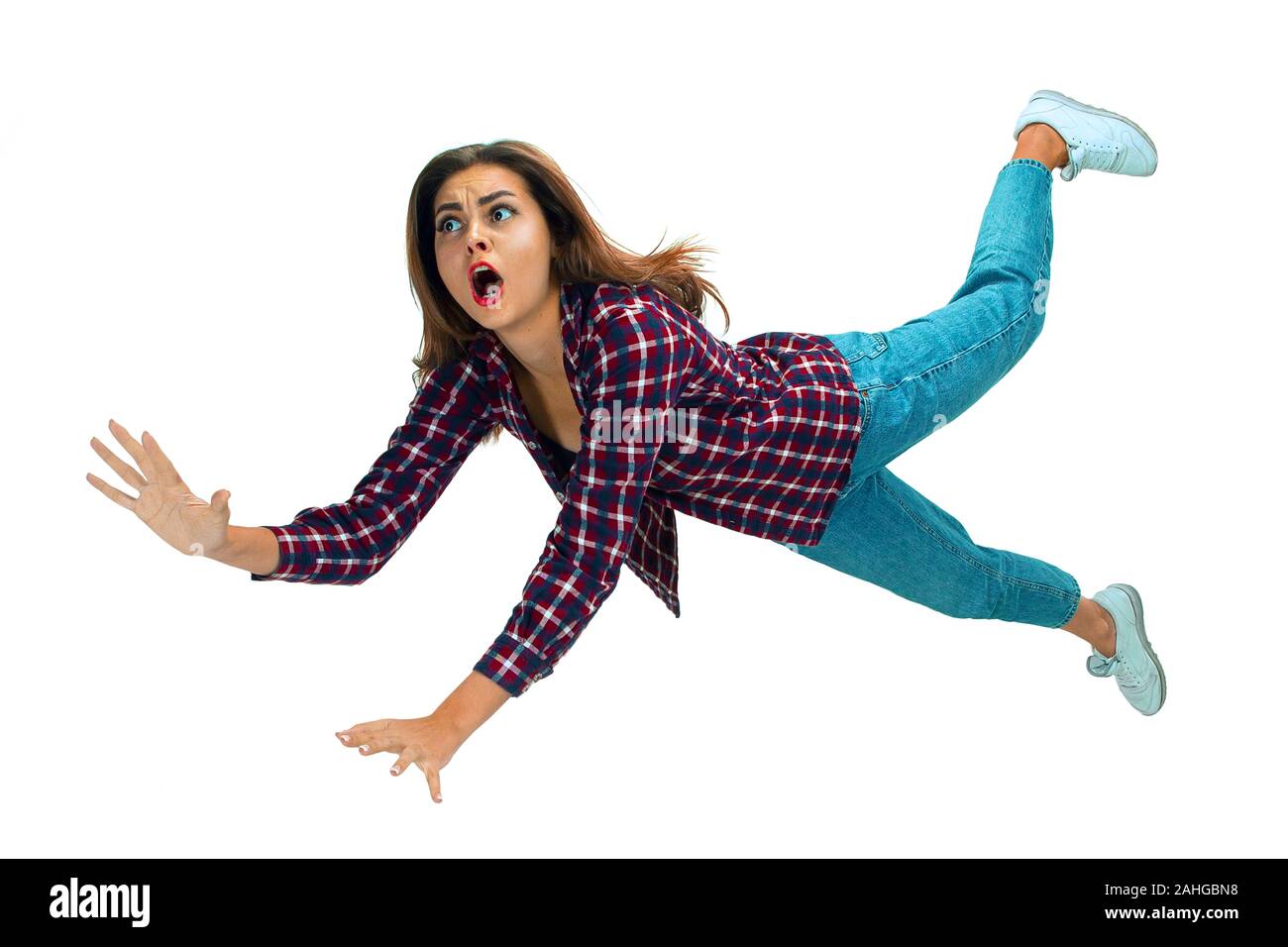 Une seconde avant de tomber. Portrait jeune fille tomber en moment avec des émotions et de l'expression du visage. Modèle féminin en vêtements décontractés. Choqué, terrifié, criant. Copyspace pour ad. Banque D'Images